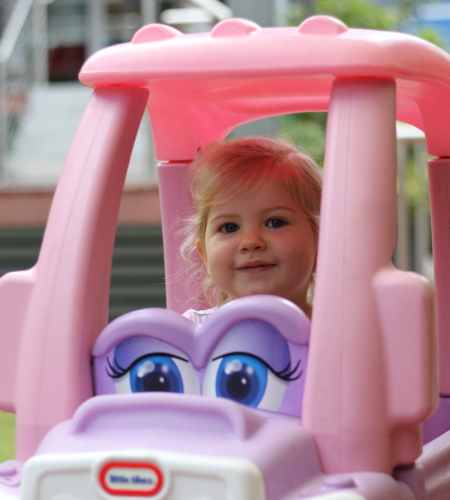 Girl in ride on car at playgroup